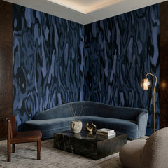 Ettore Burl wallpaper mural shown in living room with blue sectional and black table