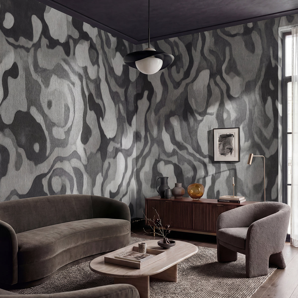 Ettore Line wallpaper mural shown in living room with grey sofa and grey armchairs