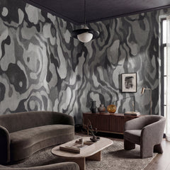 Ettore Line wallpaper mural shown in living room with grey sofa and grey armchairs