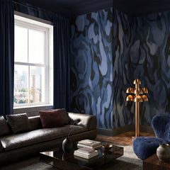 Ettore Veins wallpaper mural shown in living room with black sofa and blue chair