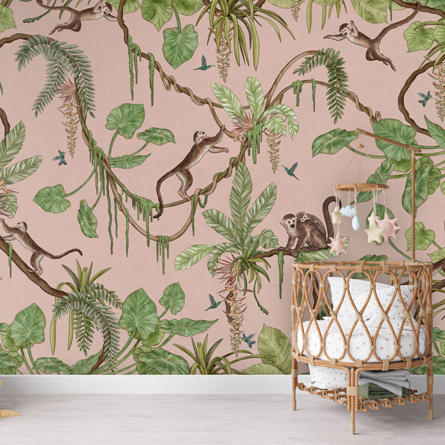 Playful Monkeys – Pink wallpaper mural in a nursery rattan cot
