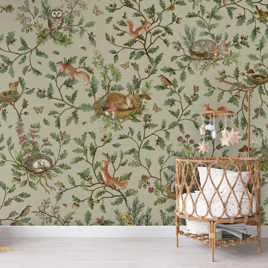 Playful Woods – Green wallpaper mural in a nursery rattan cot
