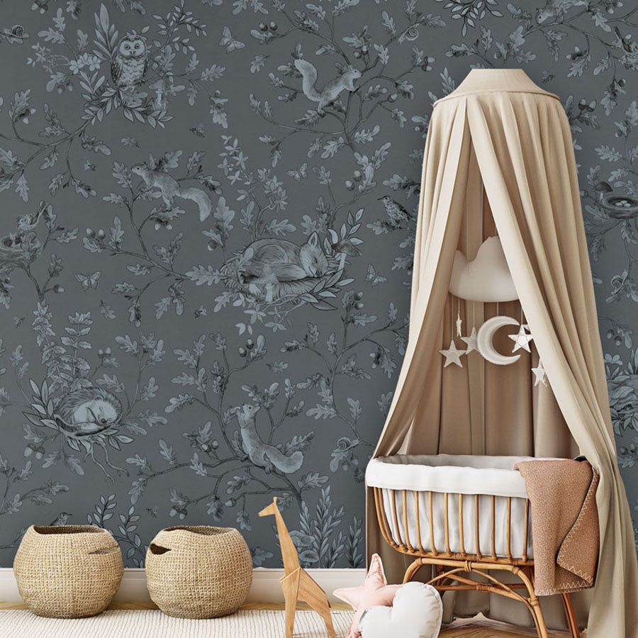 Playful Woods – Monochrome Blue wallpaper mural in a nursery rattan cot canopy