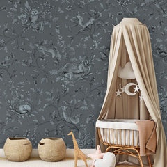 Playful Woods – Monochrome Blue wallpaper mural in a nursery rattan cot canopy