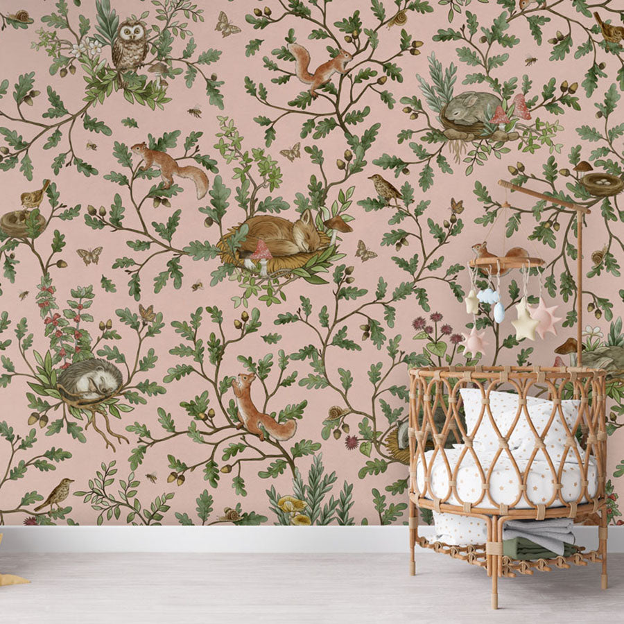 Playful Woods – Pink wallpaper mural in a nursery rattan cot