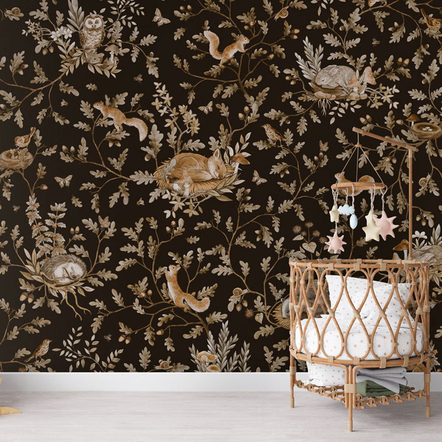 Playful Woods – Vintage Black wallpaper mural in a nursery rattan cot
