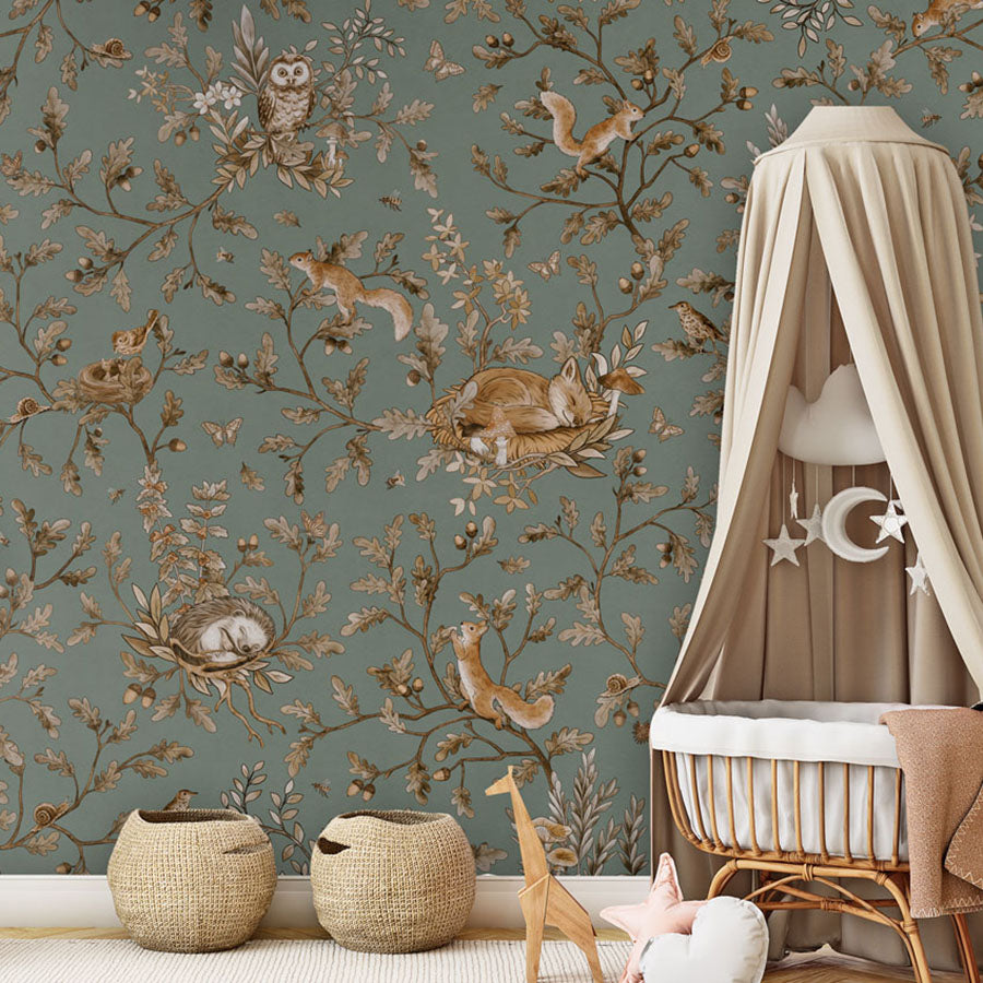 Playful Woods – Vintage Green wallpaper mural in a nursery rattan cot canopy