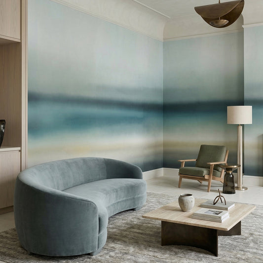 Rotko Blush wallpaper mural shown in living room with blue curved sofa and wood chair