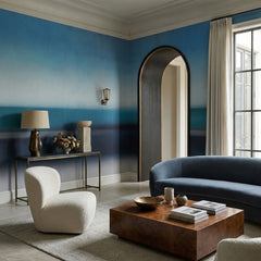 Rotko Veil wallpaper mural shown in living room with blue sofa and white boucle chair